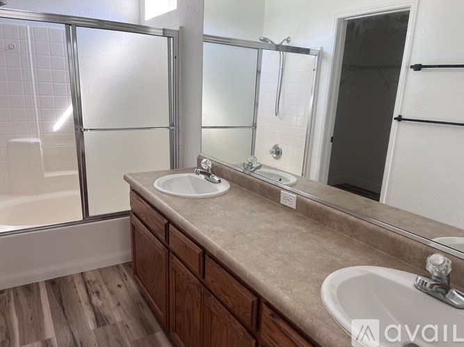 A bathroom with a sink, mirror, and bathtub.