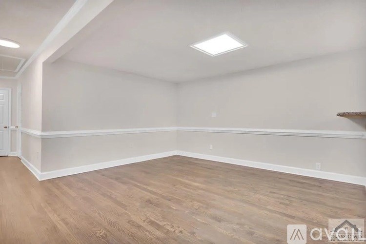 A room with wooden flooring and white walls.
