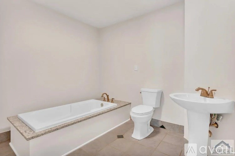 A white bathroom with a bathtub, toilet, and sink.