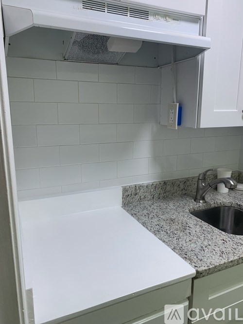 A kitchen with a sink and a white cabinet.