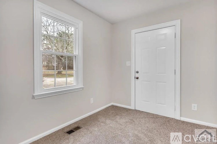 A room with a white door and window.