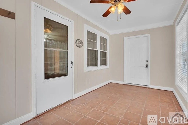 A room with a ceiling fan and tile flooring.
