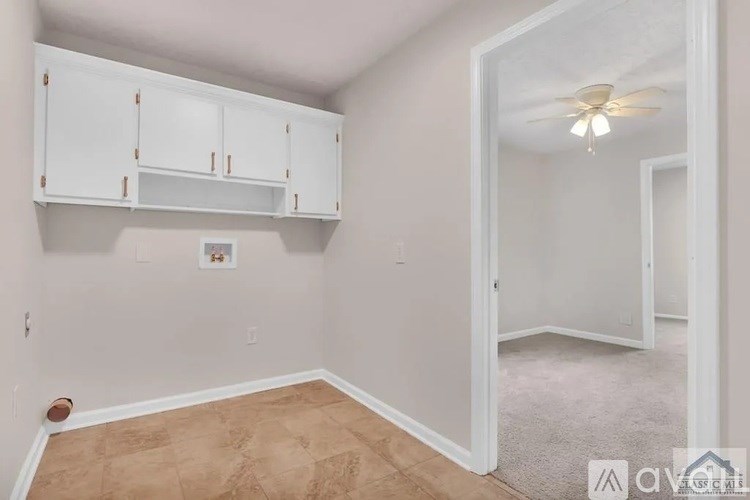 A room with white cabinets and a ceiling fan.