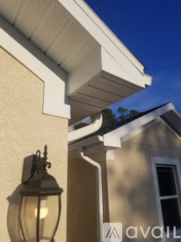 A lamp is on the corner of a house.