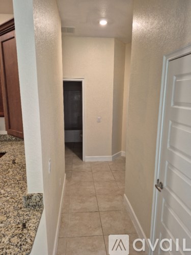 A hallway with a door on the right and a wall on the left.
