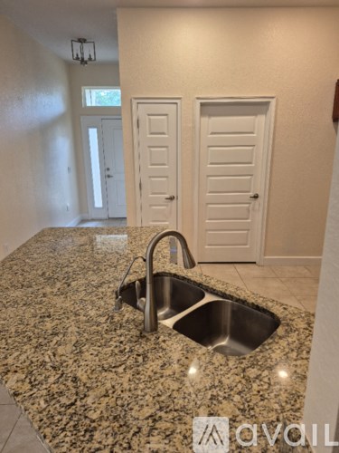 A granite countertop with a sink and a faucet.