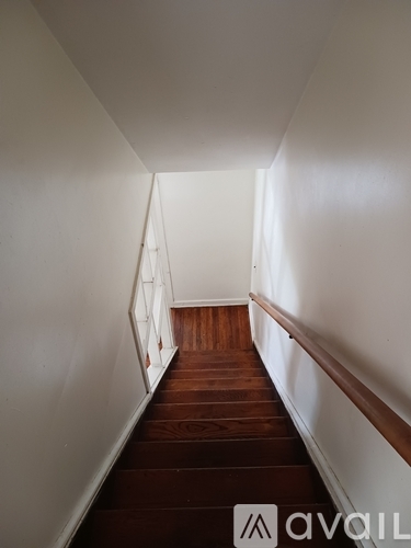 A long hallway with wooden floors and white walls.