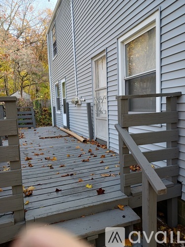 A wooden deck with a railing and steps leading to a house.