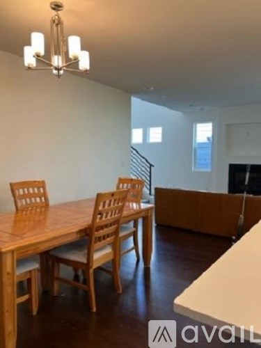 A dining room with a wooden table and chairs.