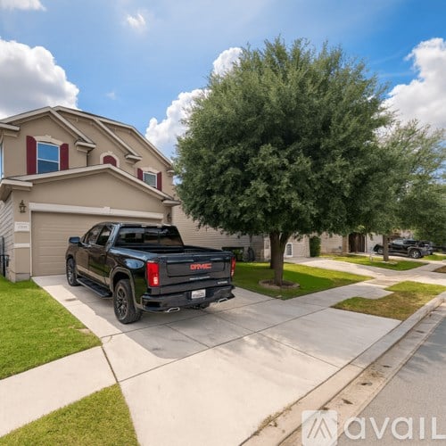 A black GMC truck is parked in front of a house.