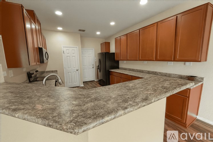 A kitchen with brown cabinets and a granite countertop.