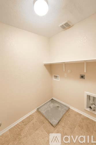 A room with a light on the ceiling and a shelf on the wall.