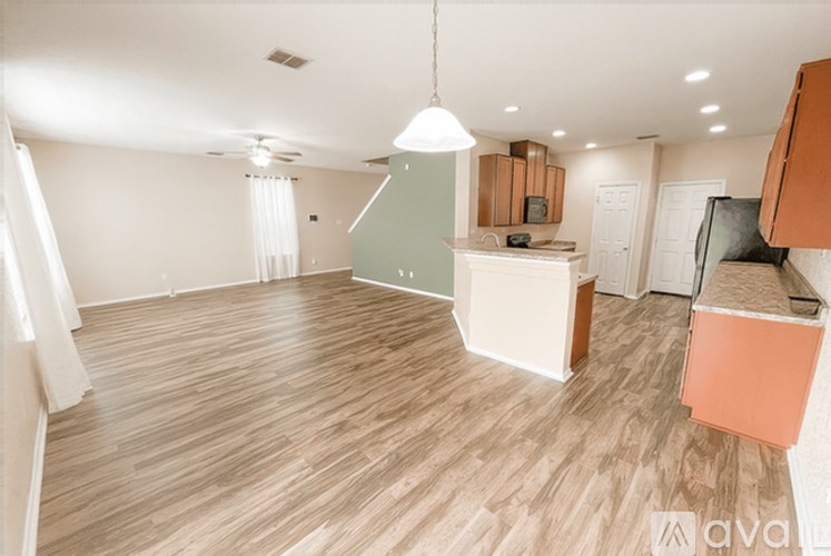 A living room with wooden flooring and a white ceiling.