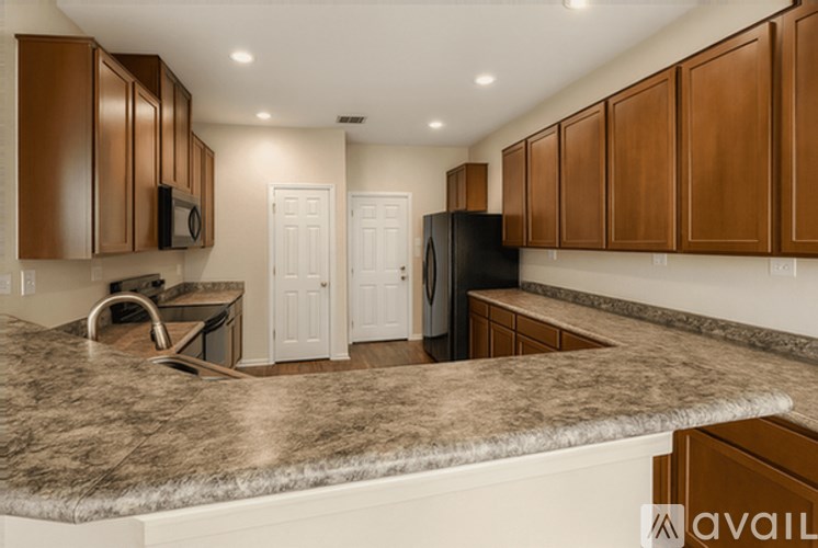 A kitchen with brown cabinets and a granite countertop.