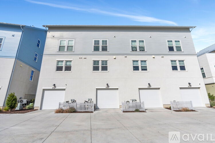 A row of white garage doors in front of a building.