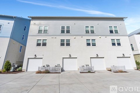 A row of white garage doors in front of a building.