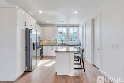 A modern kitchen with white cabinets and a wooden island.