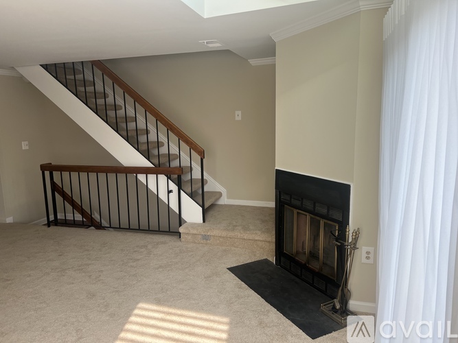 A living room with a fireplace and a staircase.