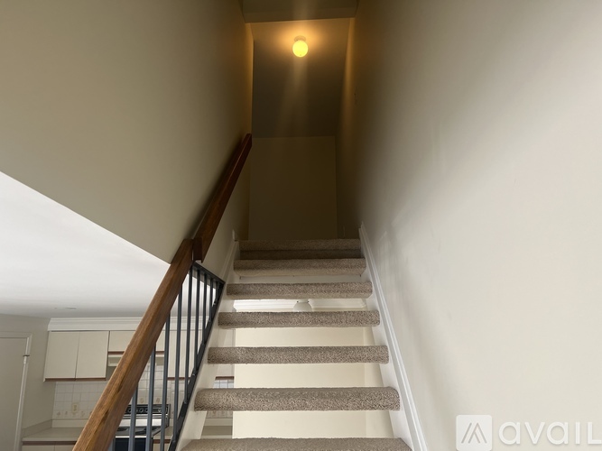 A staircase with a light on the wall at the top.