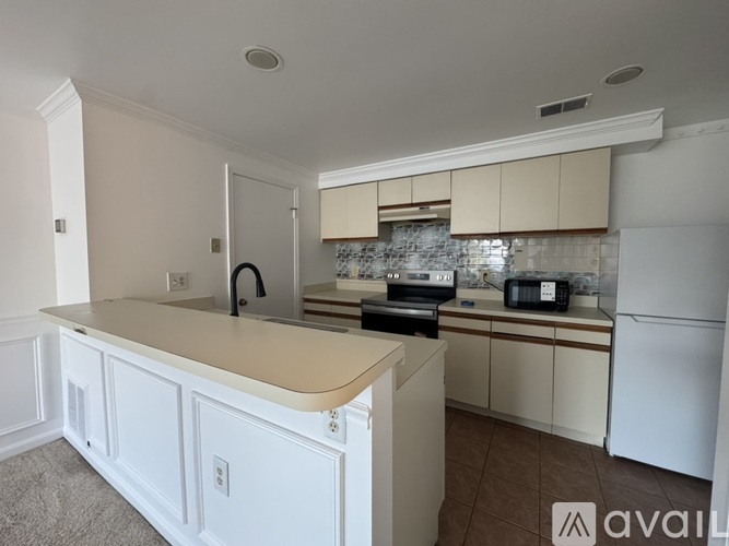 A kitchen with white cabinets and appliances.