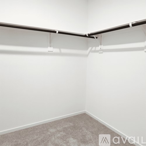 A room with white walls and a grey carpet.