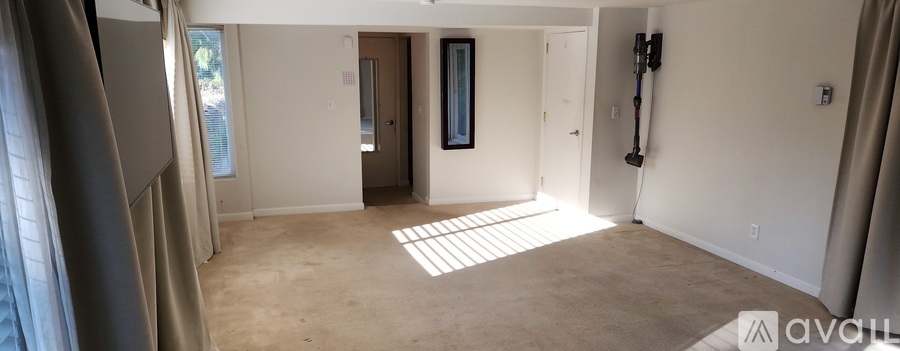 A spacious room with a doorway leading to another room.