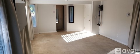 A spacious room with a doorway leading to another room.
