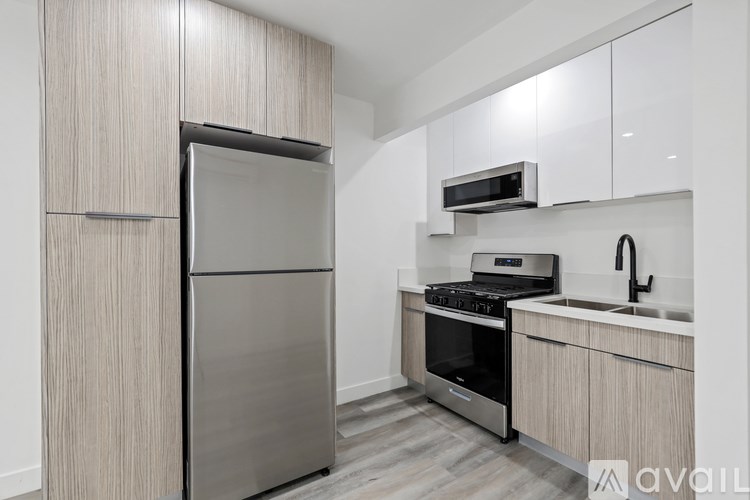 A kitchen with a refrigerator, oven, microwave, and sink.