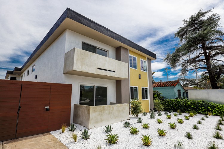 A modern house with a brown fence and a white wall.