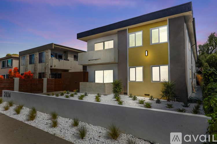 A modern house with a yellow front door is available for purchase.
