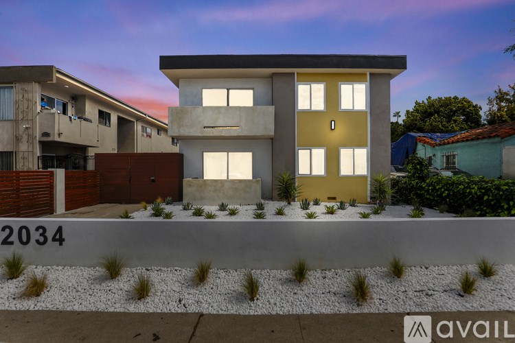 A modern house with a yellow front door is available for purchase.