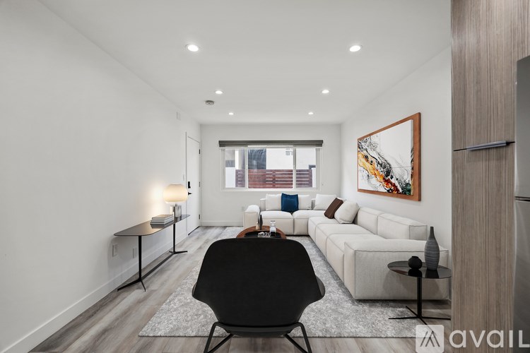 A modern living room with a black chair in the center.