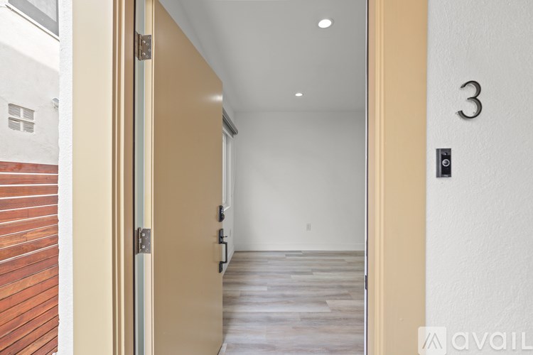A hallway with a door on the left and a door on the right with the number 3 on the right door.