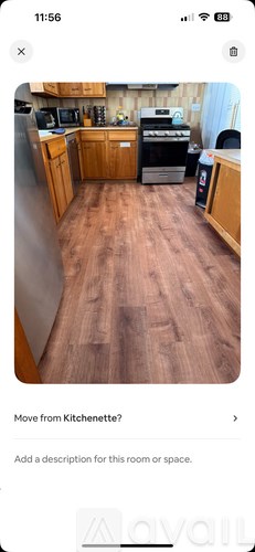 A kitchen with wooden cabinets and a stainless steel refrigerator.