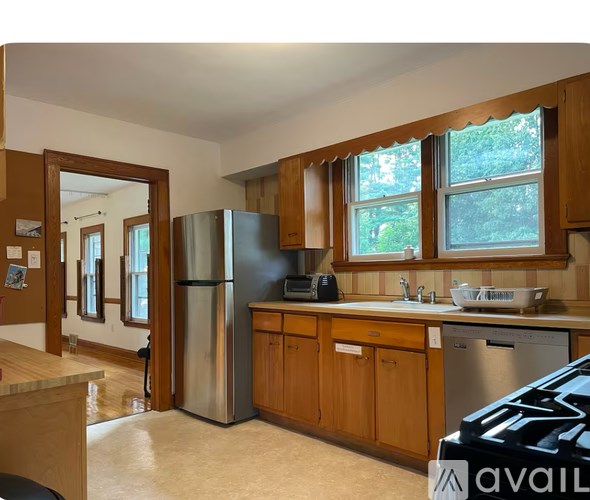 A kitchen with wooden cabinets and a black refrigerator.