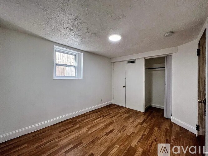A room with wooden floors and a window.