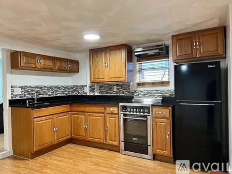 A kitchen with wooden cabinets and black appliances.