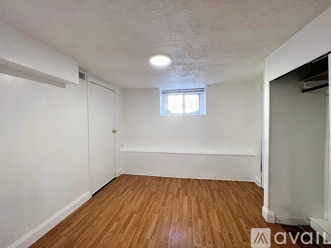 A room with wooden flooring and a window.
