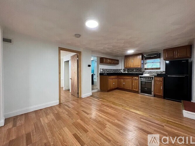 A spacious kitchen with wooden flooring and modern appliances.