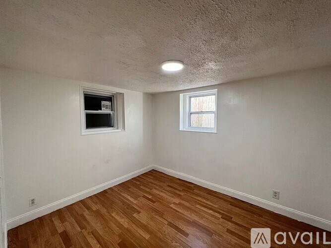 A room with wooden flooring and a window.