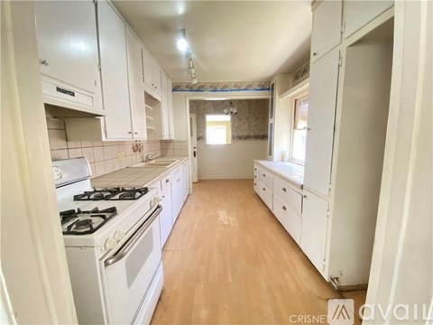 A kitchen with white cabinets and a gas stove.