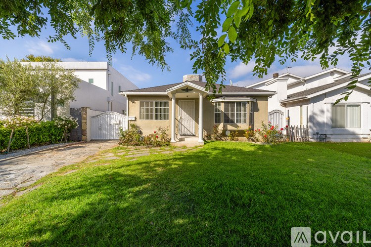 A house with a well-maintained lawn and a clear sky above.