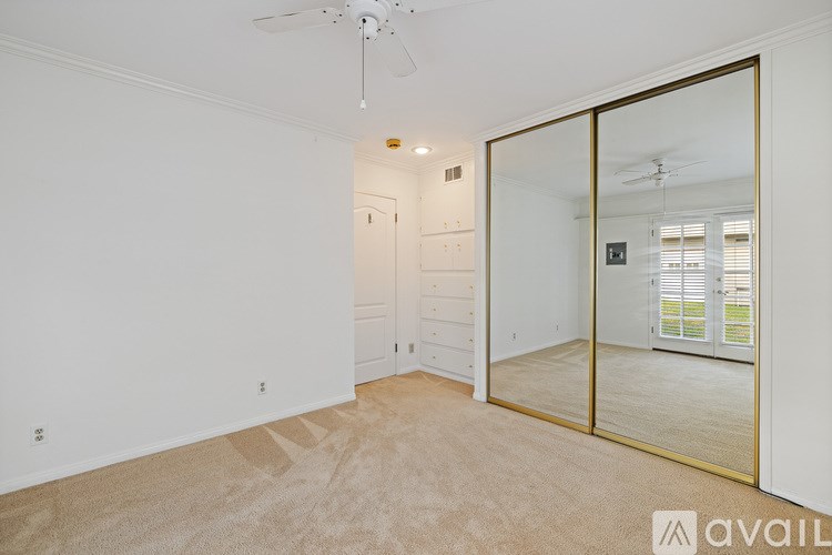 A spacious room with a ceiling fan and sliding glass doors.