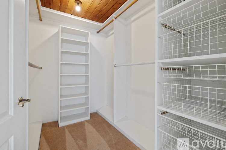 A white pantry with a white door and white shelves.