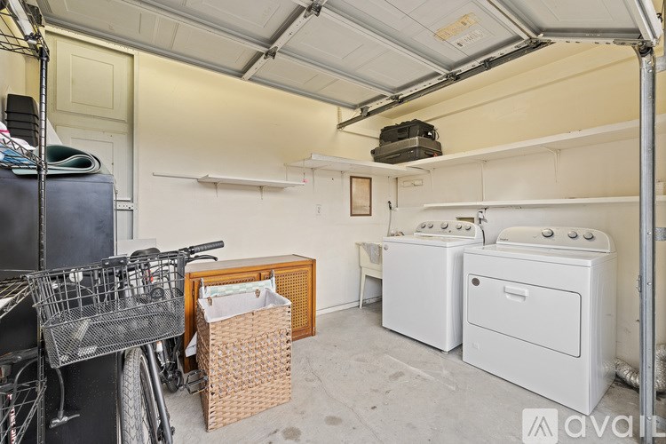 A room with a washing machine and dryer, a basket, and a bicycle.
