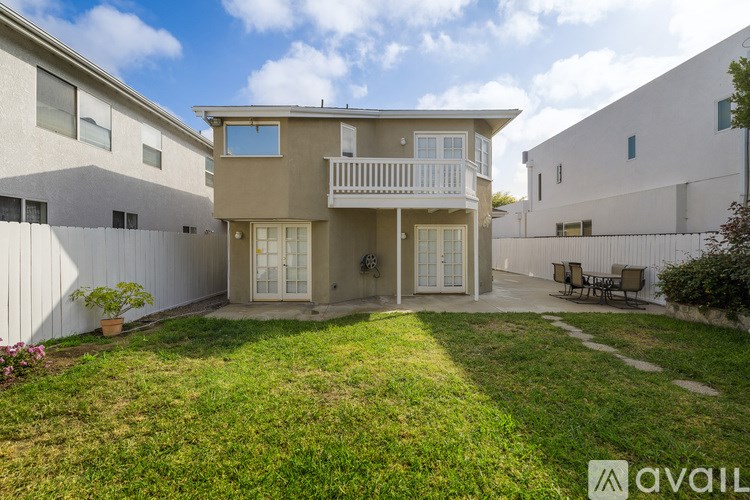 A two-story house with a balcony and a patio.