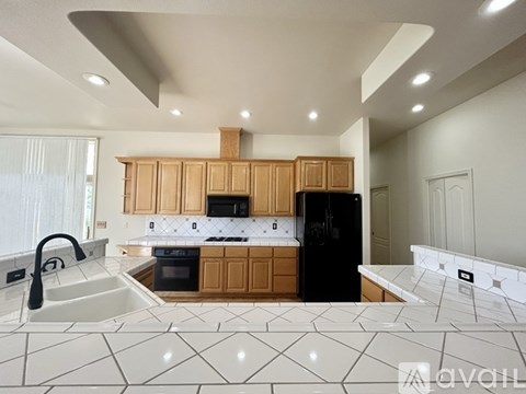 A kitchen with wooden cabinets and black appliances.