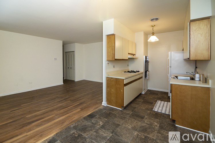 A kitchen with wooden cabinets and a tiled floor.