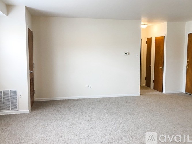 A room with wooden floors and a window with blinds.