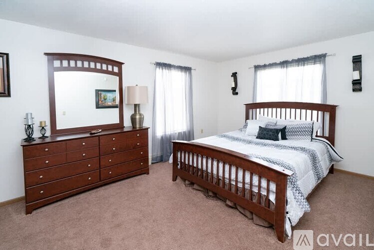 A bedroom with a bed, dresser, and mirror.